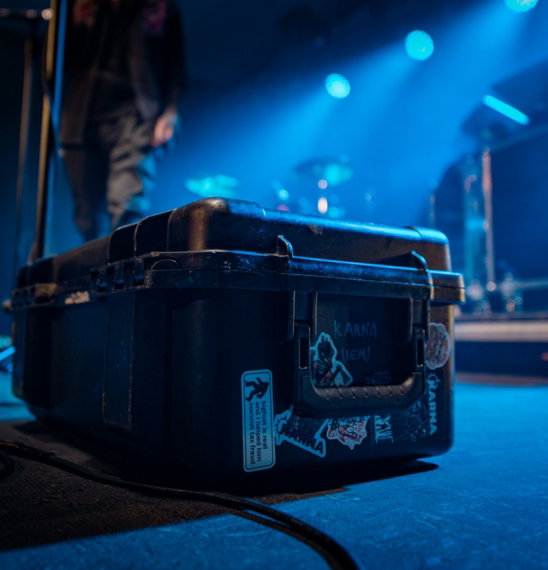 Black equipment case on a stage with blue lights